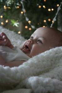 baby smiling in front of Christmas tree