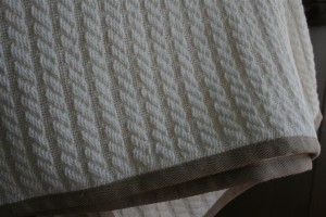 cable knit blanket with contrasting twill trim