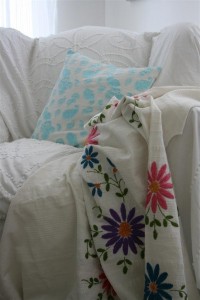 vintage turquoise pillow and embroidered coverlet