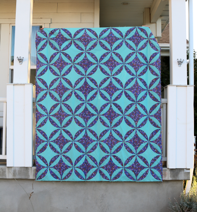 full view of hand appliqued orange peel quilt top on porch