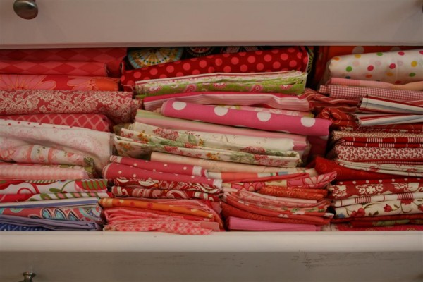 drawer filled with pink and red fabrics